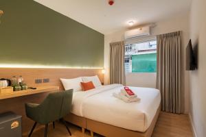 una habitación de hotel con una cama con un teléfono. en Hotel PaPa Ratchada-Huai Khwang, en Bangkok