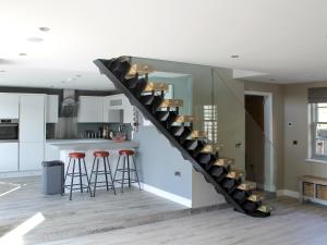 a staircase in a kitchen with stools and a counter at Ivy Cottage in Beck Hole