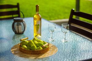 a bottle of wine and a bowl of apples on a table at Panorama Beach in Chrani
