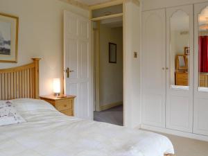 ein Schlafzimmer mit einem weißen Bett und einer Lampe auf einem Tisch in der Unterkunft Oak Tree Cottage - E5062 in Lydbrook + 10 Fotos