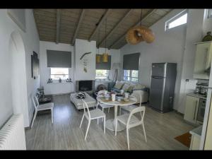 a kitchen and living room with a table and chairs at Pipina's Beach Apartment in Fanari