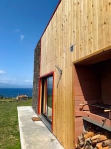 a house with a red door on the side of it at Casa Al Mare in Canto da Areia +7 photos