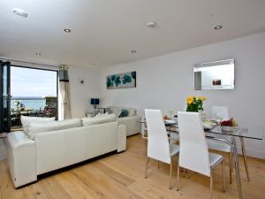 een woonkamer met een witte bank en een tafel bij 4 Ocean Point in Croyde