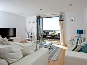 een woonkamer met een witte bank en een tafel bij 4 Ocean Point in Croyde