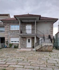 ein Haus mit einer steinernen Einfahrt davor in der Unterkunft Casa Playa Meira in Moaña