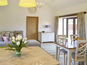 a living room with a table and a dining room at Swallows Retreat in Hartland