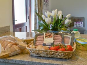 a basket of food on a counter with a vase of flowers at Swallows Retreat in Hartland