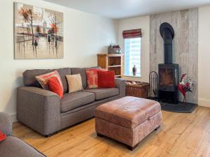 ein Wohnzimmer mit einem Sofa und einem Holzofen in der Unterkunft Townend Cottage in Aikton