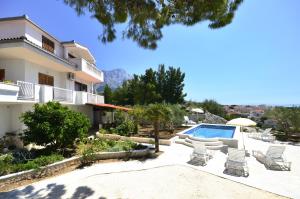 バシュカ・ヴォダにあるFamily-friendly apartments with swimming pool Baska Voda, Makarska - 12442のプールと家のあるヴィラ