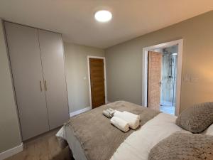 a bedroom with a bed with two towels on it at Britlodge Home in Manchester
