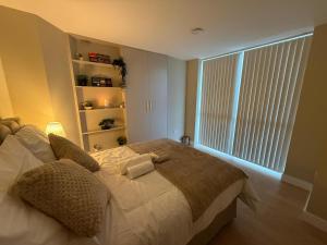 a bedroom with a bed and a large window at Britlodge Home in Manchester