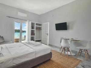 une chambre avec un lit, une table et une télévision dans l'établissement Holiday Nest, à Porto Heli