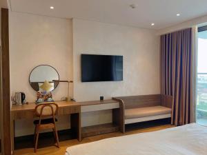 a hotel room with a desk and a television at Yang Apec Mandala Home in Phước Hậu (1)