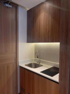 a kitchen with a sink and wooden cabinets at Yang Apec Mandala Home in Phước Hậu +8 photos