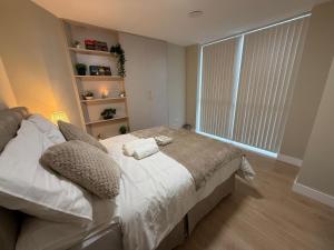 a bedroom with a bed with pillows and a window at Britlodge Home in Manchester +23 photos