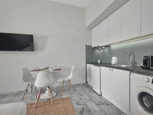 - une cuisine avec une table, un évier et un lave-linge dans l'établissement Holiday Nest, à Porto Heli