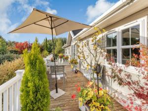 a wooden deck with an umbrella on a house at Beech Tree Lodge in Willington