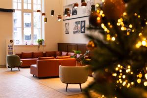 Una sala de estar con un sofá y un árbol de Navidad. en DoubleTree by Hilton Sittard, en Sittard