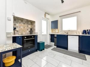 ReynoldstonにあるBrynviewのタイルフロアのキッチン(青いキャビネット付)