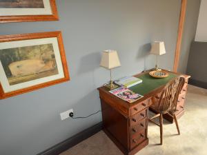 einem hölzernen Schreibtisch mit zwei Lampen darüber in der Unterkunft Chiddock Cottage - Ukc2540 in Fordingbridge