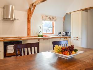 eine Küche mit einem Tisch mit einer Obstschale darauf in der Unterkunft Chiddock Cottage - Ukc2540 in Fordingbridge + 19 Fotos