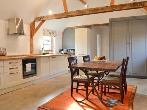eine Küche mit einem Esstisch aus Holz und Stühlen in der Unterkunft Chiddock Cottage - Ukc2540 in Fordingbridge