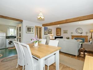 a kitchen and living room with a table and chairs at The Mains in Keldhead