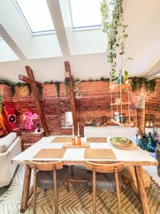 Un comedor con una mesa y una pared de ladrillos. en Skatta Secret Penthouse, en Helsinki