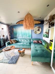 sala de estar con sofá verde y lámpara de araña en Skatta Secret Penthouse, en Helsinki