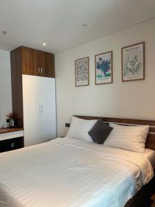 a bedroom with a large white bed with two pillows at Yang Apec Mandala Home in Phước Hậu