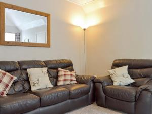 a brown leather couch in a living room with a mirror at Eagles Gate Lodge in Banff
