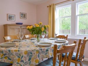 a dining room table with a vase of flowers on it at Eagles Gate Lodge in Banff