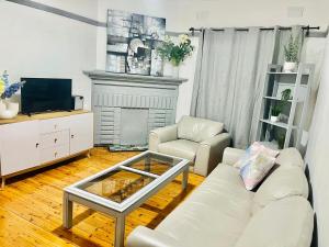 un salon avec un canapé blanc et une télévision dans l'établissement A Cosy Private Corner in the City, à Sydney