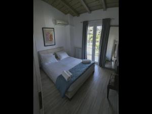 a bedroom with a bed and a window at Pipina's Beach Apartment in Fanari