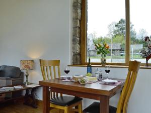 a dining room with a table and chairs and a window at Little Barn in Gilwern