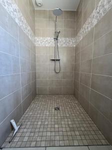 y baño con ducha alicatada y cabezal de ducha. en Gîte neuf, à 12mn du Futuroscope, à la campagne-Le Coquelicot, en Saint-Léger 15 fotos más