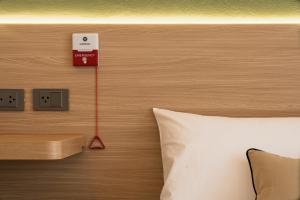 Un cabecero de cama con un reloj encima en Hotel PaPa Ratchada-Huai Khwang, en Bangkok