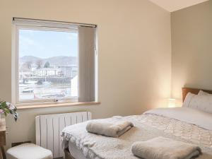 South Snowdon Wharf في بورثمادوج: غرفة نوم بها سريرين ونافذة