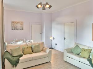 een woonkamer met een bank en een tafel bij Elfin Cottage - Uk7810 in Coirantee