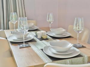 een eettafel met borden en wijnglazen bij Elfin Cottage - Uk7810 in Coirantee +10 foto's