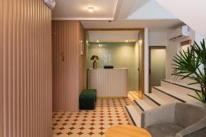 a lobby with a staircase with a table and chairs at Hotel PaPa Ratchada-Huai Khwang in Bangkok
