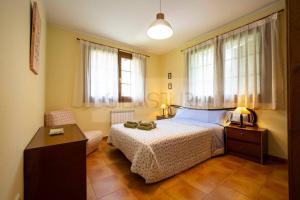 a bedroom with a bed and a desk and windows at Casa Sildavia By Silastur in La Riera