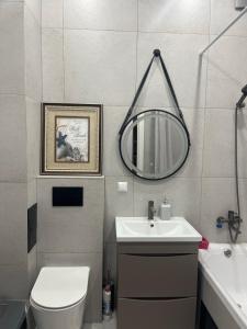 a bathroom with a sink and a toilet and a mirror at Kolsay in Kirovo +20 photos