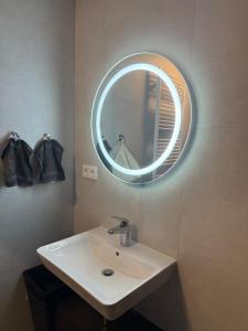 a bathroom with a sink and a mirror on the wall at Modern Apartment in a Leafy Town Close to Prague 