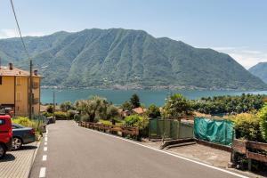 una carretera con vistas al lago y a las montañas en Typical stone house with balcony, en Ossuccio
