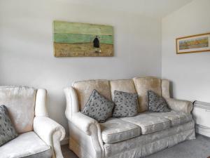 ein Sofa und zwei Stühle im Wohnzimmer in der Unterkunft Trevose Head - Uk47556 in Saint Merryn