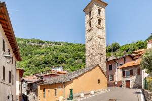 un edificio con una torre de reloj en una ciudad en Typical stone house with balcony, en Ossuccio
