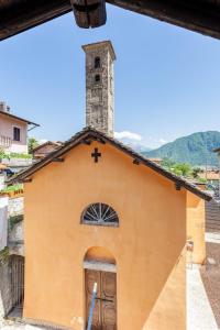 una iglesia con una cruz encima en Typical stone house with balcony, en Ossuccio