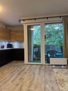 にあるModern Apartment in a Leafy Town Close to Pragueのパティオに通じるガラスの引き戸のある空のキッチン