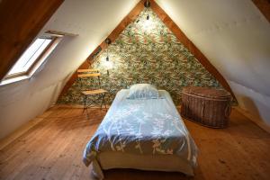 een slaapkamer met een bed op zolder bij Gîtes calmes écologiques in Saint-Symphorien